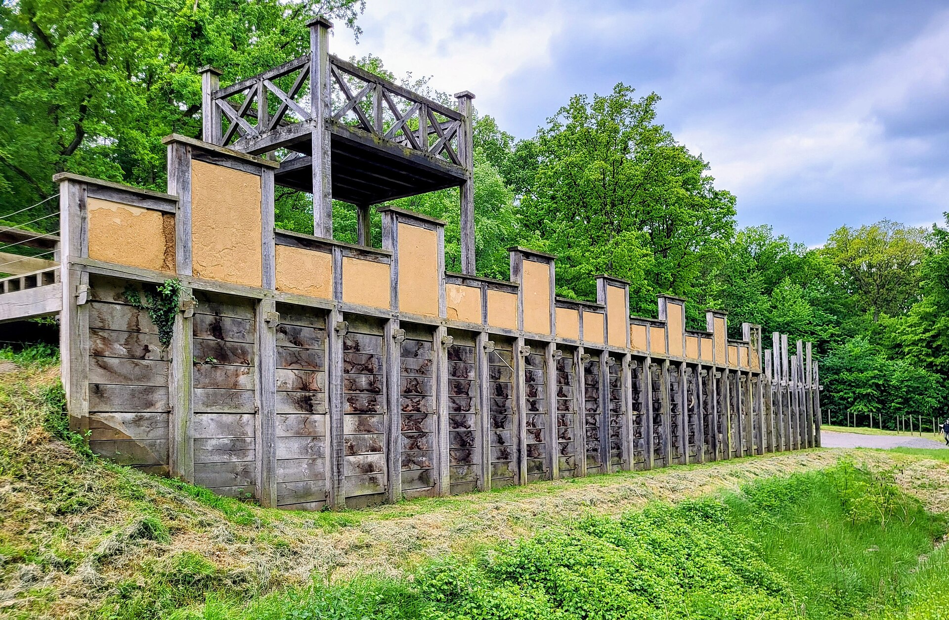 Rekonstruierte römische Holz-Erde-Mauer mit Holzturm im Römerpark Bergkamen, davor der Graben