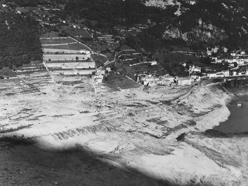 Historische Schwarzweißaufnahme der U.S. Army (SETAF) vom Oktober 1963: Wo vor dem 9. Oktober 1963 die Kleinstadt Longarone im Piave-Tal stand, erstreckt sich nach dem Durchgang der Flutwelle nur noch eine graue Geröll- und Schlammwüste mit freigelegten Fundamentresten.