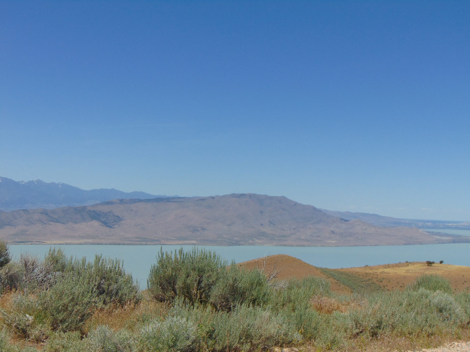 Blick über den Utah Lake auf den kargen Höhenzug der Lake Mountains in Utah County